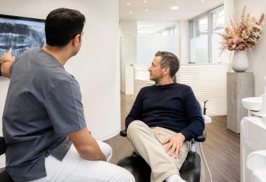 Zahnarzt erklärt einem Patienten Karies im Zahnzwischenraum anhand einer Röntgenaufnahme